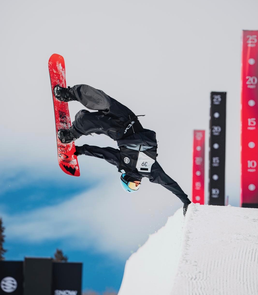 Jonas Hasler performing a handplant on a snowboard halfpipe wall